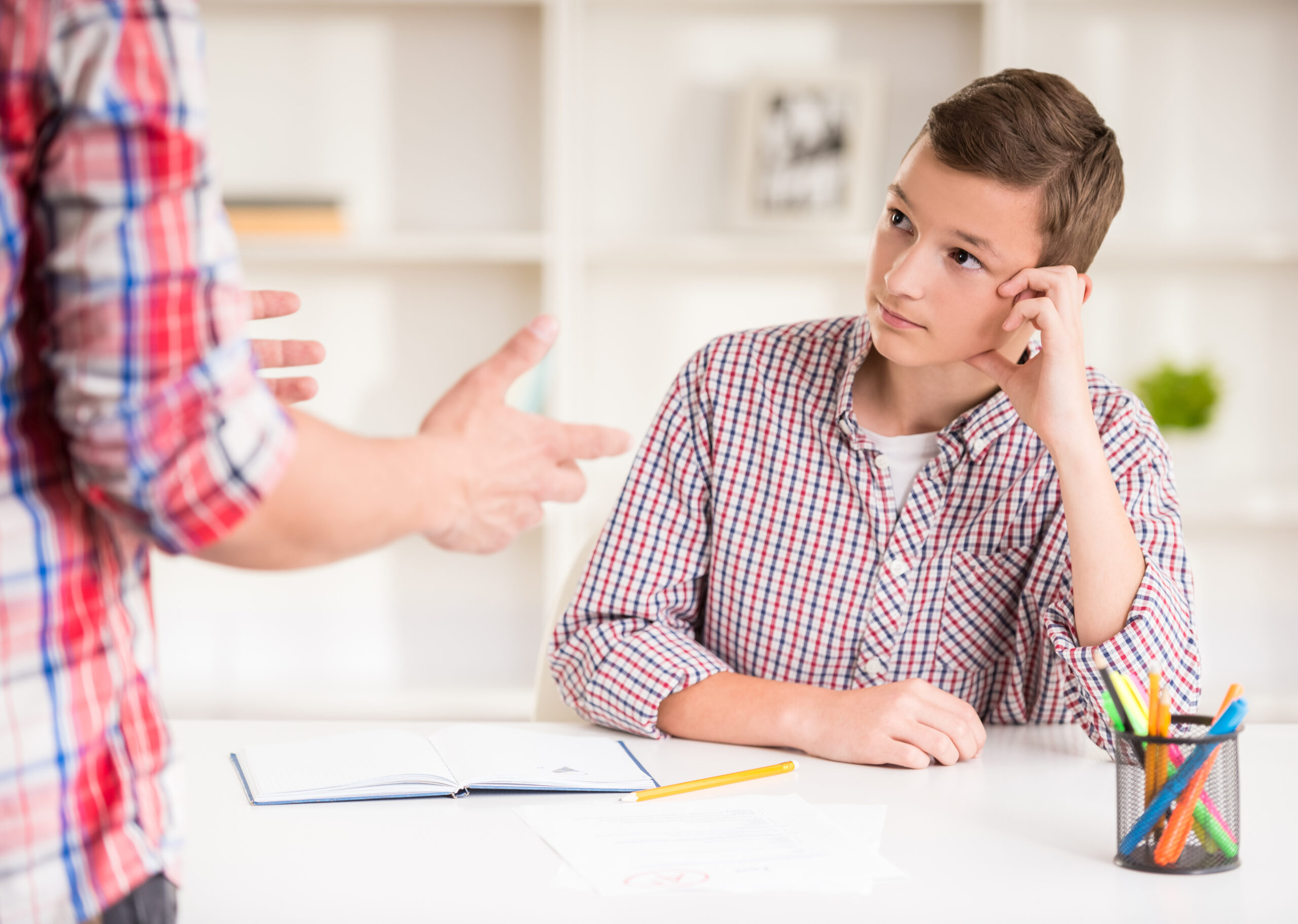 Father helping his son to do homework at home.