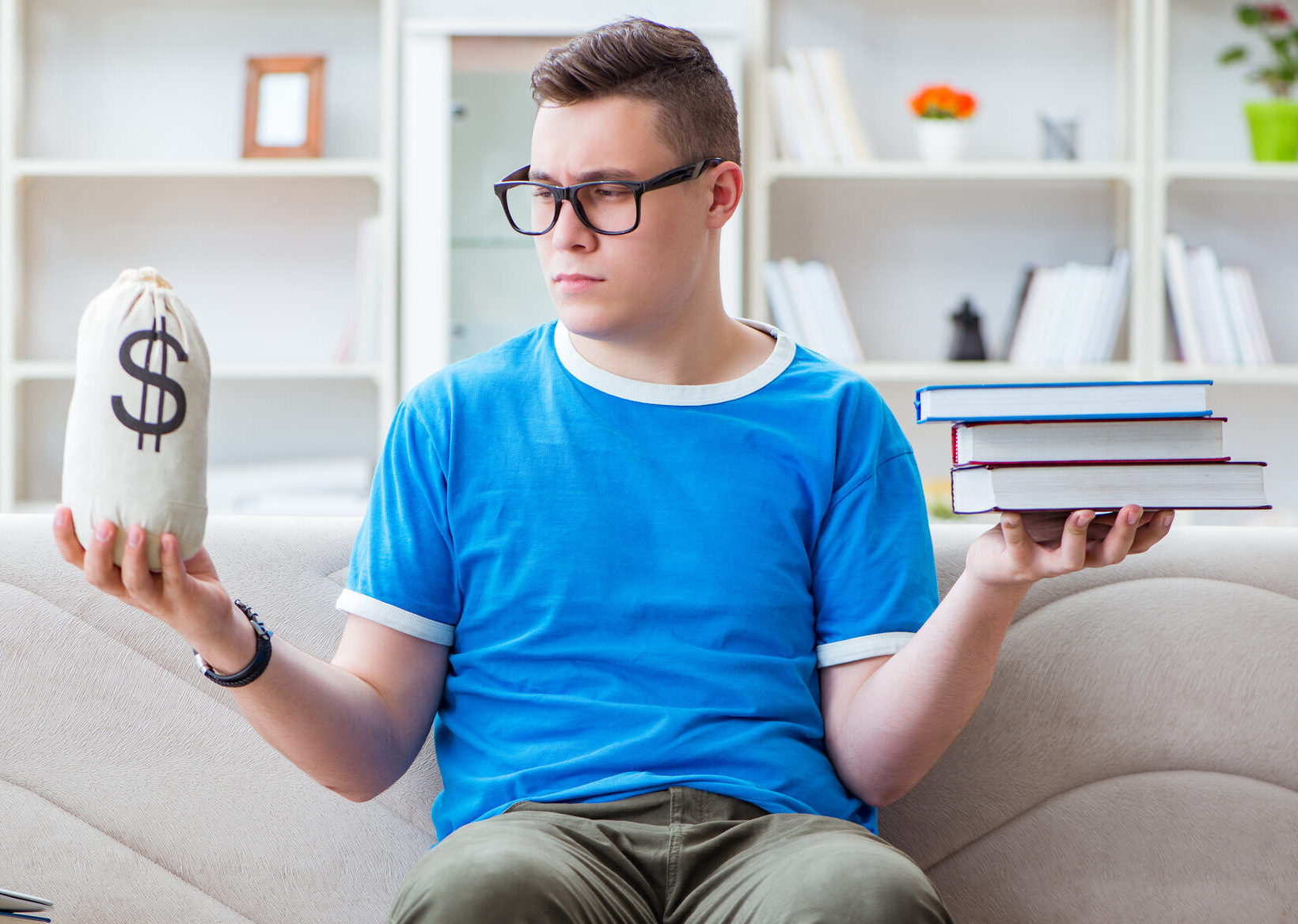 Young student preparing for exams studying at home on a sofa