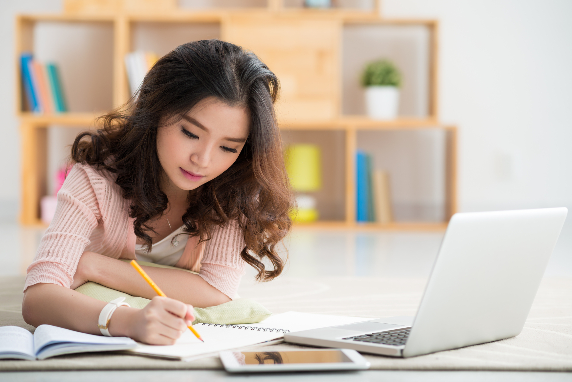 Asian girl working on her school project at home.