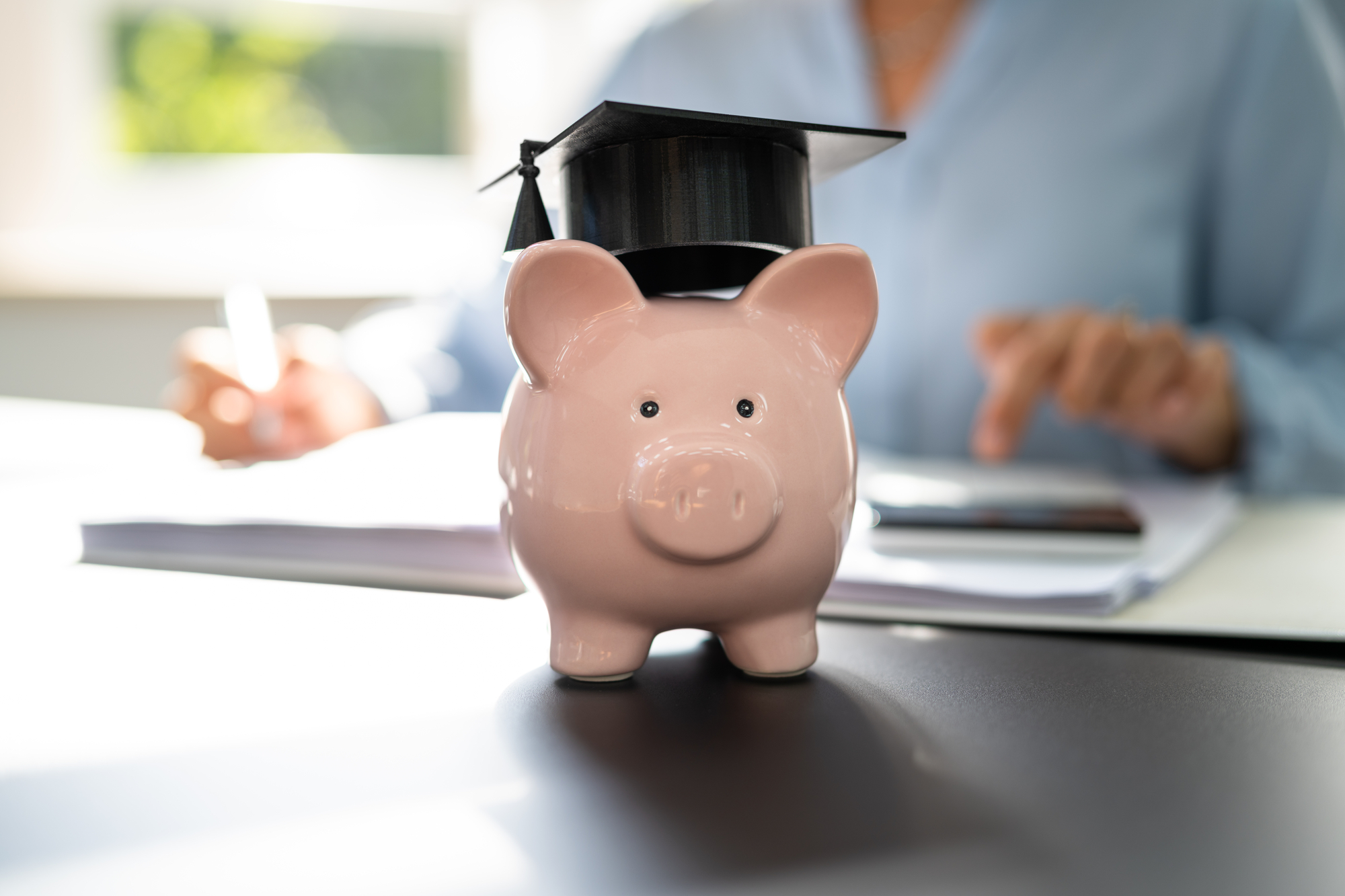 Piggy bank with a graduation cap on head.