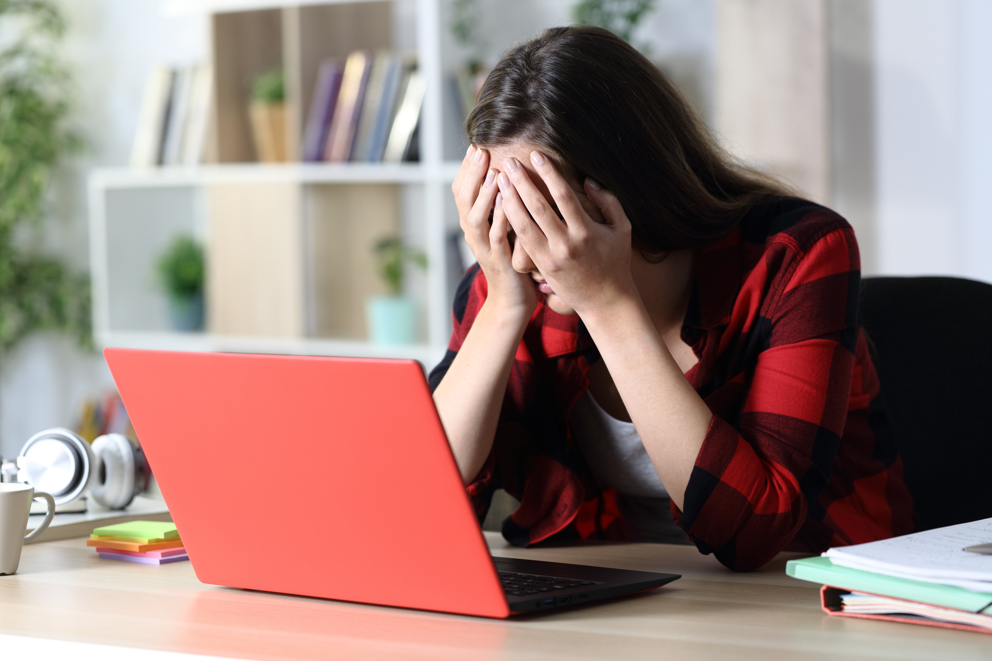 Girl sitting at laptop frustrated.