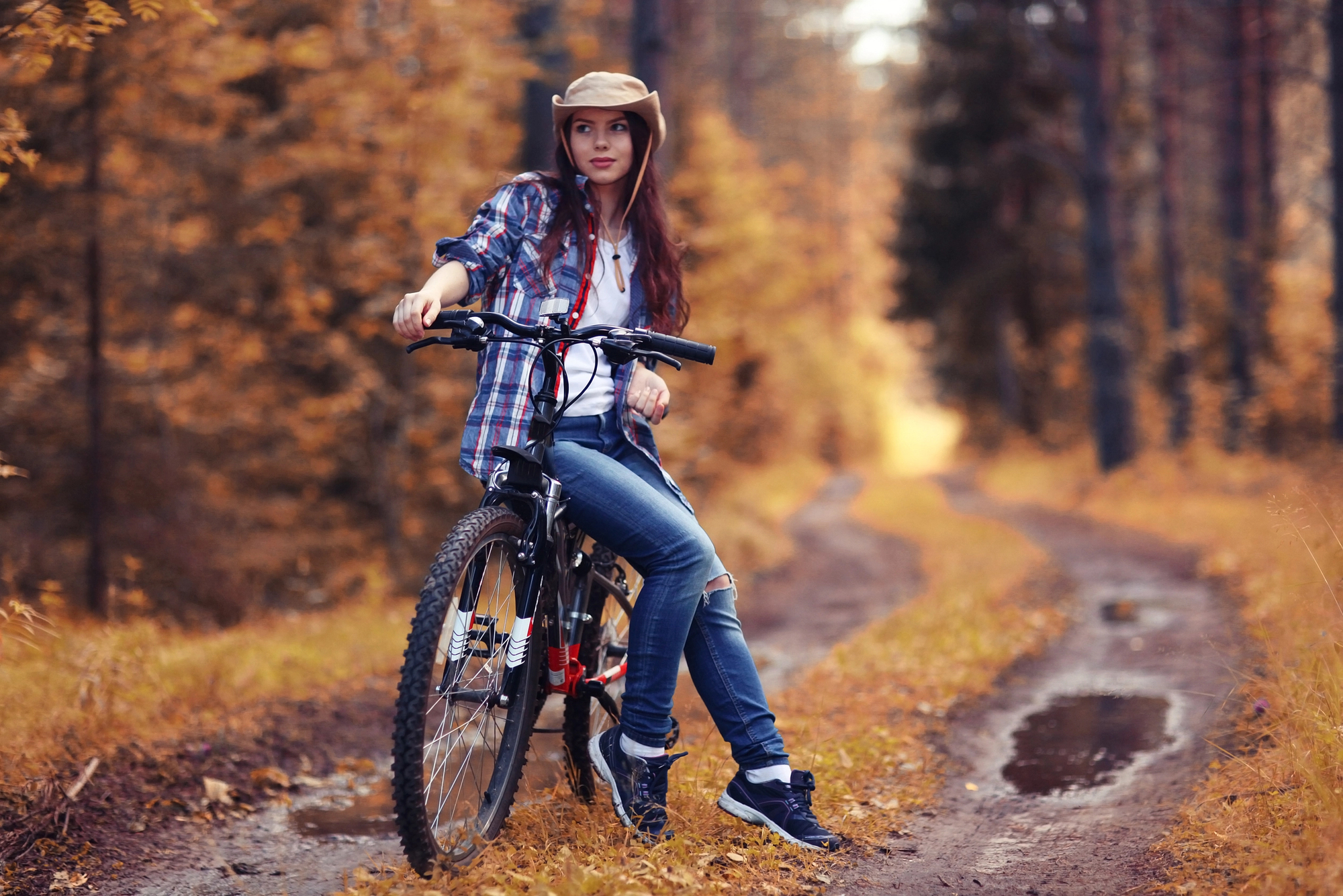 Teen girl riding bike in the forest.