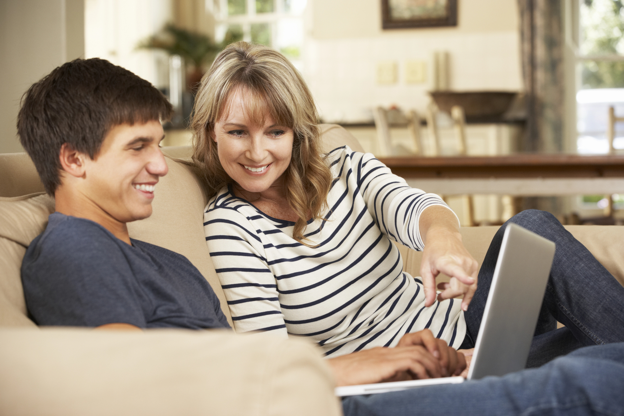Mom and son sitting on couch looking at computer