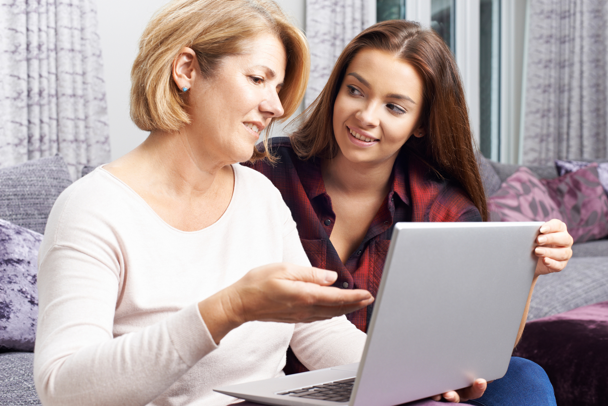 Mother talking to daughter while looking at computer.