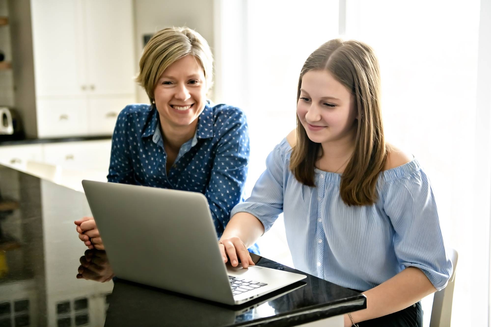 Mother and teen daughter looking at computer screen