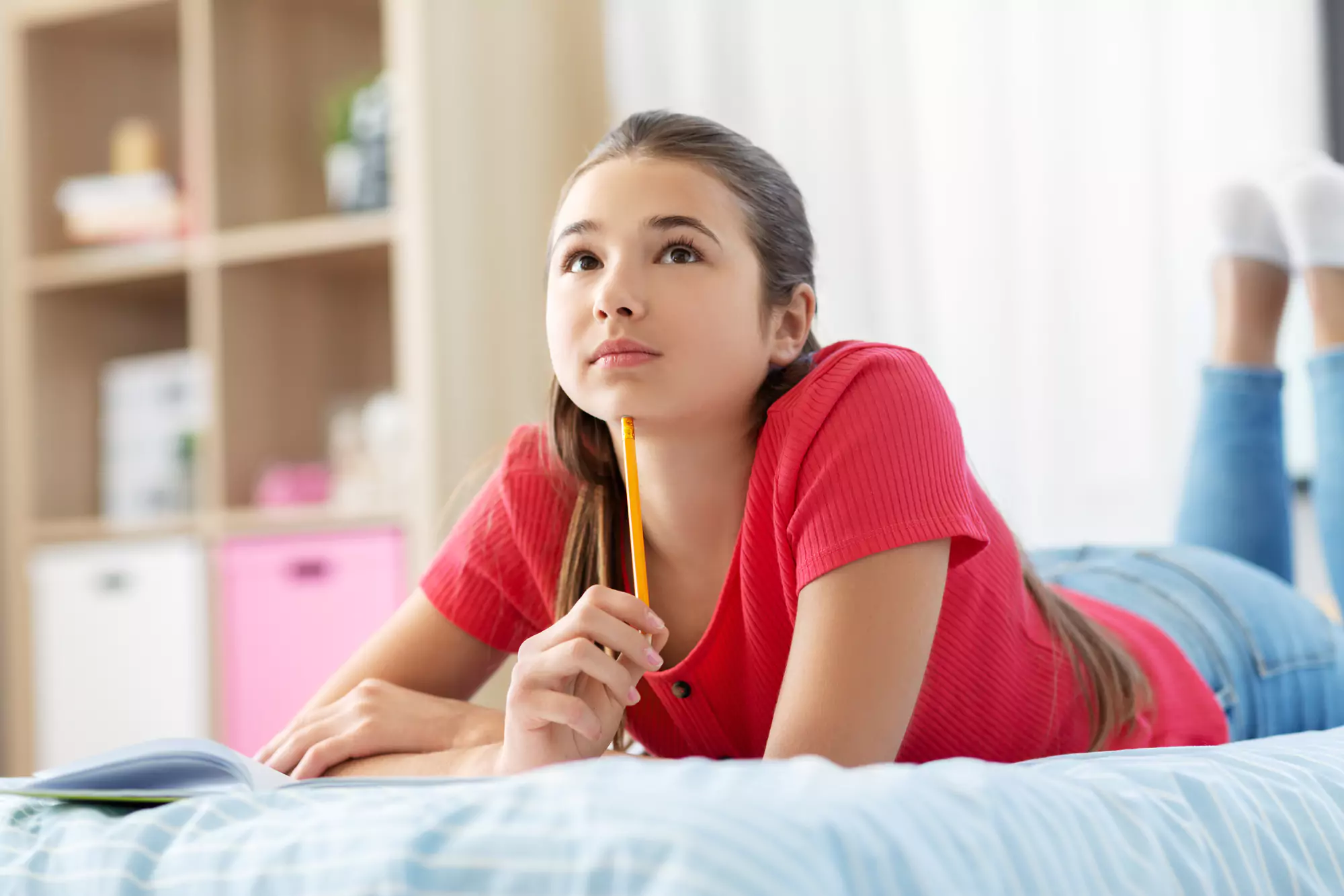 Teen girl laying on bed thinking