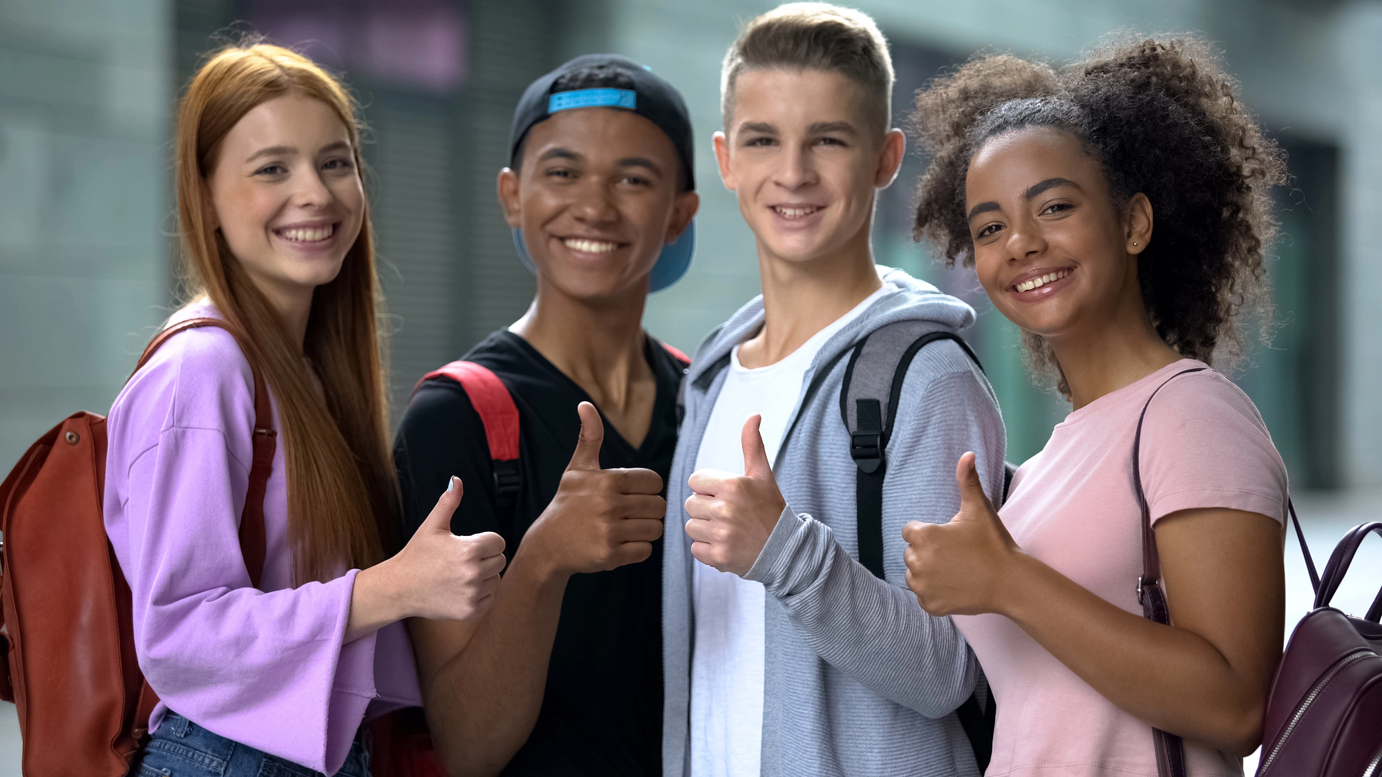 Group of teenage kids giving a thumbs up.