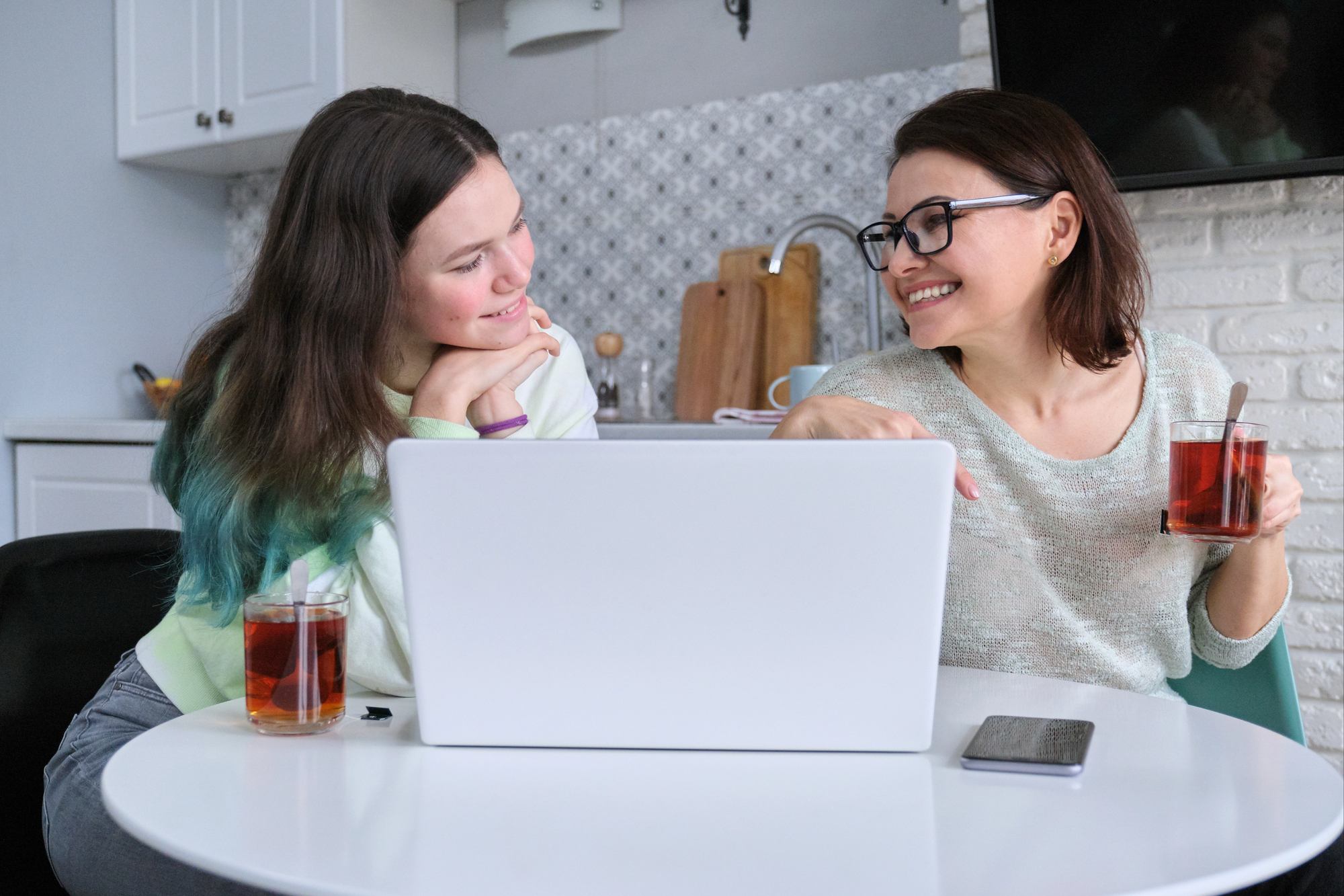 mother and daughter having a conversation in their kitchen.