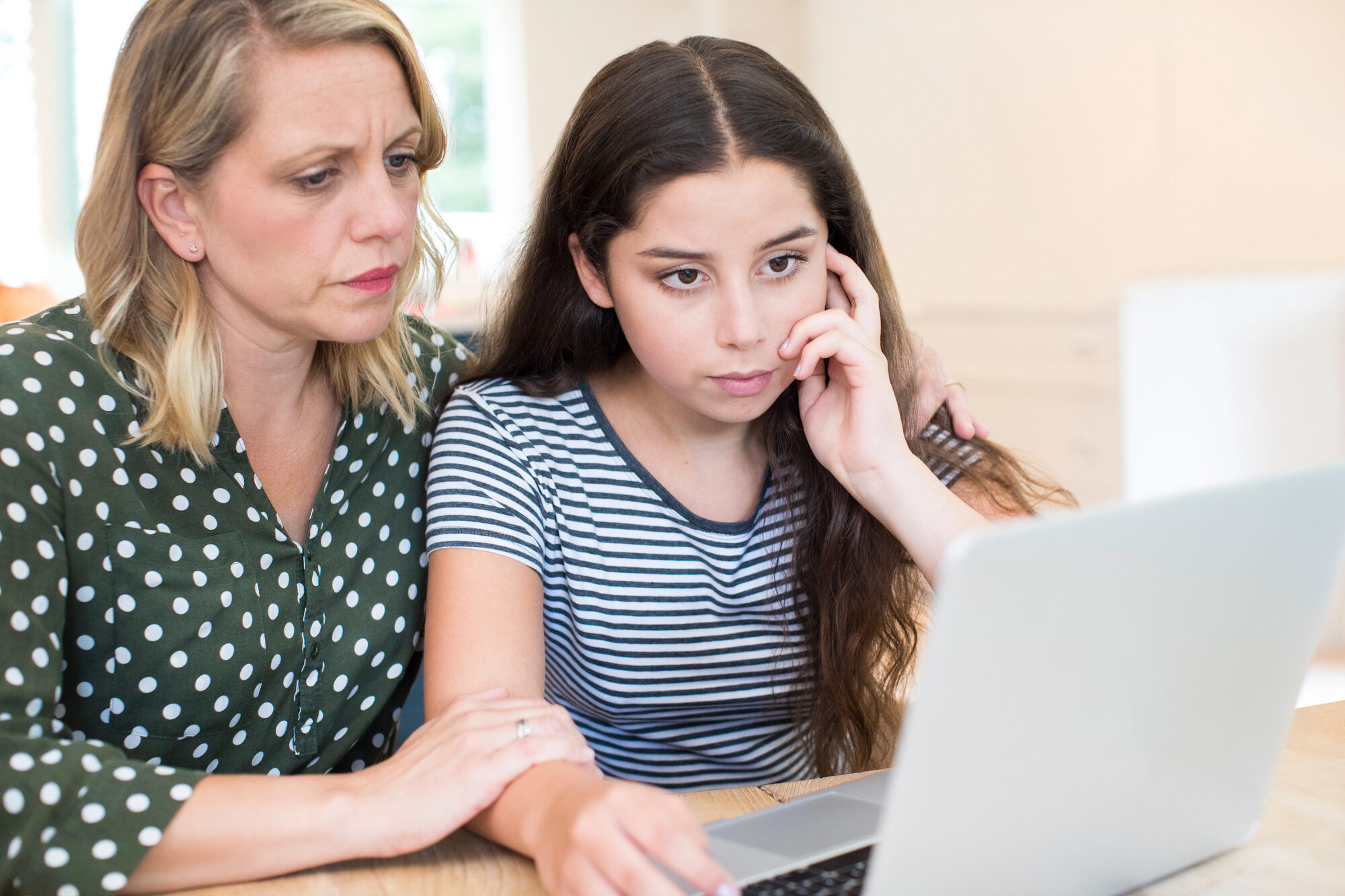 Mother and teen daughter looking at computer screen