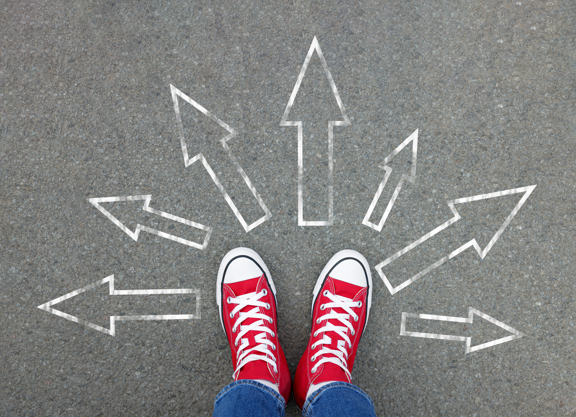 Teen standing at a crossroads with arrows pointing in multiple directions, symbolizing college decision paths