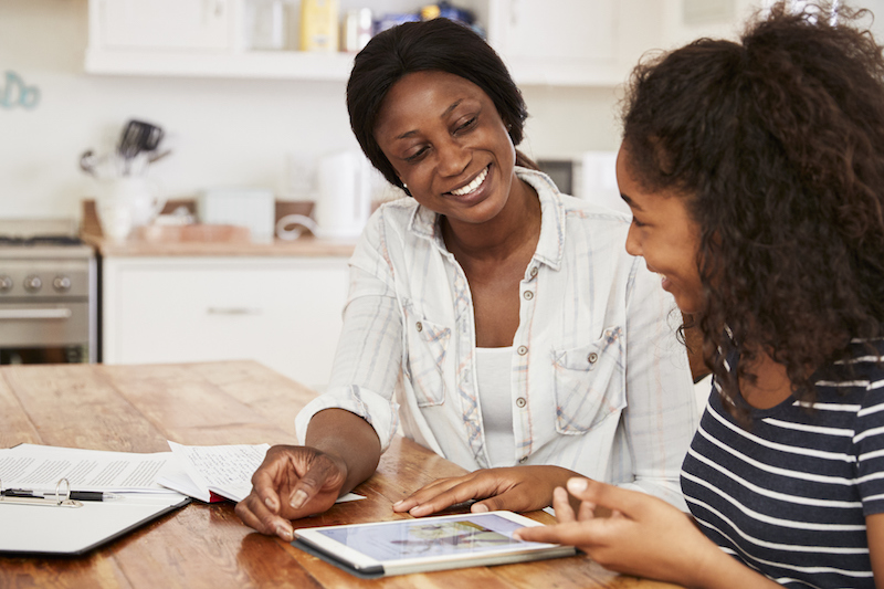 Parent and teen reviewing college planning information together while discussing future options