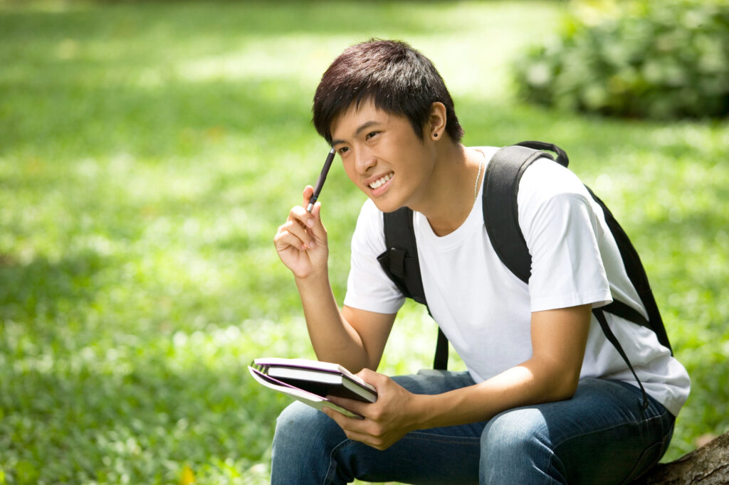 teen boy writing in a journal