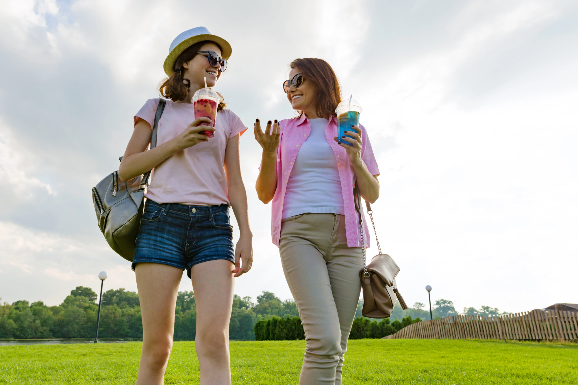 Mother and teenage daughter walking outdoors together and talking casually, representing low-pressure conversations about the teen’s future