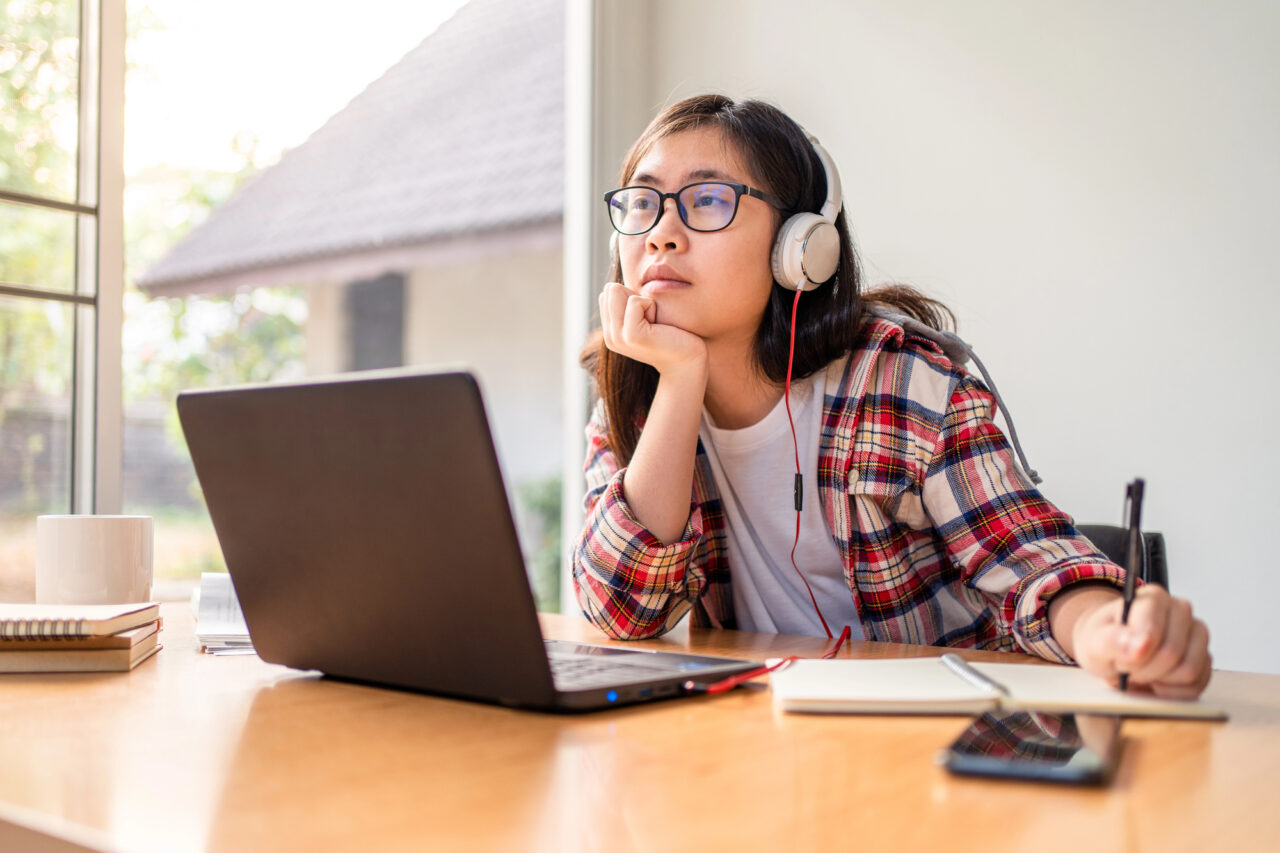 Teen sitting at desk looking at computer